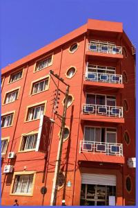 塔那那利佛雷莱斯诺曼德酒店的一座高大的红色建筑,设有窗户和阳台