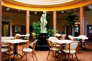 米什科尔茨道波曹伊甸文德哈茨酒店的一间带桌椅和雕像的餐厅