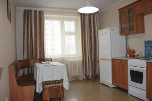 秋明Апартаменты на Пермякова的厨房配有桌子和白色冰箱。