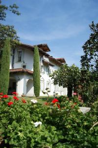 MontafiaVillagaia Country House的一座带红色和白色花卉花园的房子