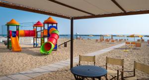 贝拉里亚-伊贾马里纳里维埃拉酒店的海滩上带椅子和桌子的游乐场