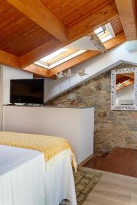 圣地亚哥－德孔波斯特拉Numa Rúa Travesa的一间卧室设有石墙和带天窗的天花板。