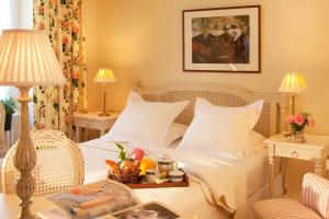 坎佩尔嘉德隆酒店的一间卧室配有一张白色的床和两张带台灯的桌子。