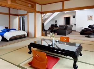 函馆元町全景公寓的卧室配有一张床和一张桌子及椅子