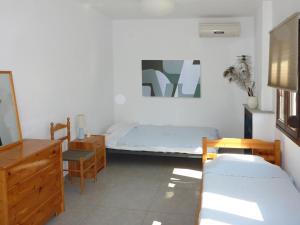 莫拉卡里瓦Villa Mola Kalyva的卧室配有1张床、1张桌子和1把椅子