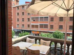 巴拉卡宙斯旅馆的阳台配有2张桌子和雨伞。
