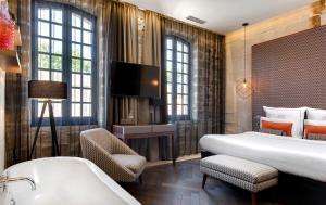 艾格-莫尔特Boutique Hôtel des Remparts & Spa的酒店客房配有一张床和浴缸。