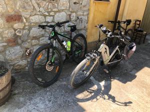 CollesanoAgriturismo Ilardo的两辆自行车停在石墙旁边