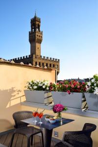 佛罗伦萨圣佛罗伦萨套房Spa酒店的一个带桌椅的庭院和塔楼