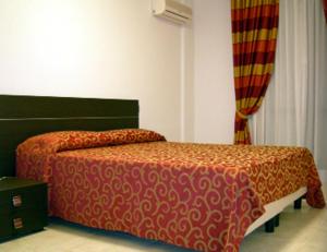 卡利亚里万特佳住宿酒店的一间卧室配有一张红色棉被的床
