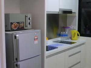 努沙再也KiddyPalace@Meridin的厨房配有微波炉和冰箱。