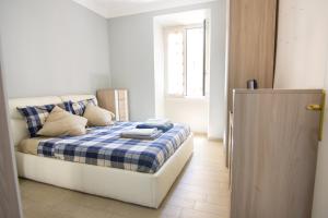 罗马Appartamento Tadolini的一间卧室配有一张带蓝白格子毯子的床