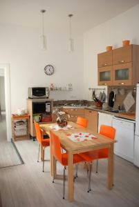 维亚雷焦Casa dolce casa的厨房配有木桌和橙色椅子