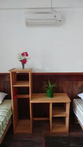 LagudriNew Raya - Nias Beach Bungalows的一间房间,配有两张床和一张桌子,上面有植物