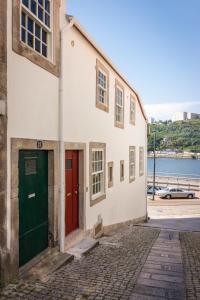 波尔图Douro River Studios的街上有红色门的白色建筑