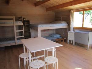 马藏La Grange de Campaulise - Camping à la ferme - Hébergements - Mont Ventoux的客房设有双层床、桌子和凳子。