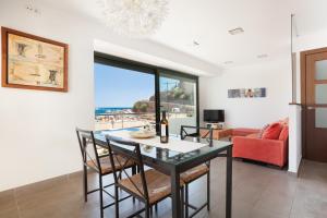 滨海托萨Lets Holidays Passeig del Mar的一间带桌椅和沙发的用餐室