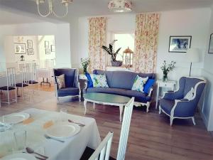 斯雷布纳古拉Folwark Leszczynówka的客厅配有蓝色的椅子和桌子