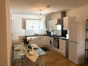 伦敦Luxurious Apartment "N22"的厨房配有桌子和白色冰箱。
