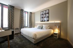瓦朗斯法兰西酒店的卧室配有一张白色大床,部分设有窗户