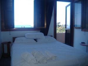 Ayia TriasTheresa Hotel at Karpaz Peninsula的卧室配有白色床和毛巾