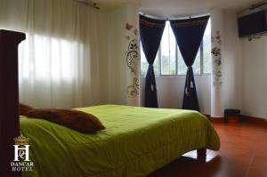 潘普洛纳Hotel Dancar的一间卧室配有带窗帘的绿色床和窗户。