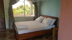 NioumachouaMohéli Vanilla Lodge的窗户客房内的一张床位