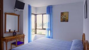 伊斯拉Hotel Candano的一间卧室设有一张床和一个窗口