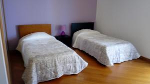 里韦拉布拉瓦Sea View House的一间卧室设有两张铺有白色床罩的木地板。