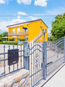 奥米沙利Appartments Adriatic的黄色房子前面的围栏