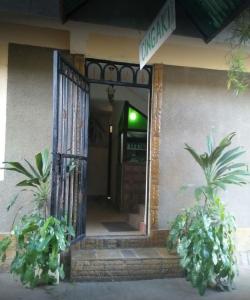 蒙巴萨Cingaki Hotel的两棵盆栽植物的房子的敞开的门