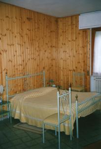 Vaglia帕德里诺酒店的木墙客房的两张床