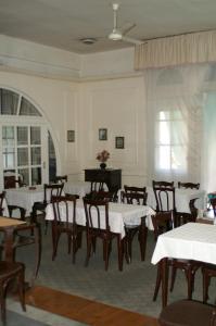 开罗Pension Roma的一间带桌椅和钢琴的用餐室
