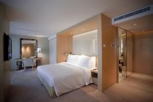 澳门City Viva Hotel Macau-Fomerly Hotel Million Dragon Macau的卧室配有一张白色大床和一张书桌