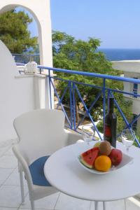 埃夫迪洛斯卡拉斯星级酒店 的一张桌子,上面放着一盘水果和一瓶葡萄酒