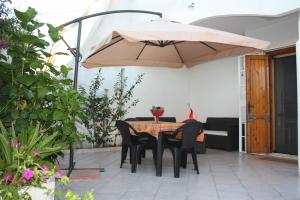 莱波拉诺Villa Salento的一个带桌子和大雨伞的庭院