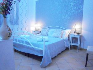 兰佩杜萨B&B La Rosa Lampedusa的蓝色的卧室,配有床和花瓶