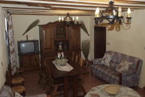 HinojaresCasa Rural La Liebre的客厅配有桌子和电视