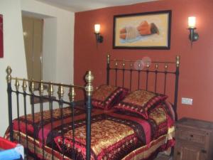 HinojaresCasa Rural La Liebre的一间卧室配有红色墙壁的床