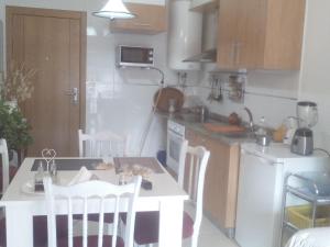博伊罗Apartamento de playa的厨房配有小桌子和白色的桌椅