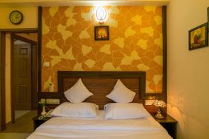 尼杜巴塞莱Blue Bell Cochin Airport Hotel的一间卧室配有一张带两个白色枕头的床