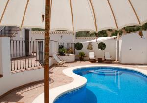 Villanueva de AlgaidasValle de Oro的一座房子旁带遮阳伞的游泳池