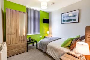 克鲁Clen Holme House的一间带绿色墙壁和床的卧室