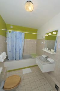 韦兹莱康波斯特拉酒店的带浴缸、卫生间和盥洗盆的浴室