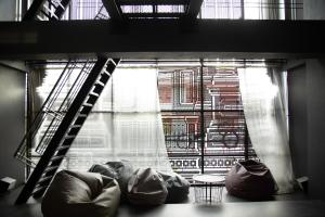曼谷伊萨拉旅舍的客房设有带梯子和沙发的窗户。