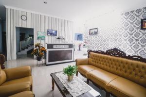 棉兰RedDoorz near Hermes Place Polonia Medan的客厅配有两张沙发和一台电视机