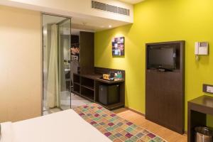 维沙卡帕特南Keys Select by Lemon Tree Hotels, Visakhapatnam的配有一张床和一台平面电视的酒店客房