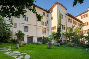 佛罗伦萨亚奇罗希酒店的长凳和草地的建筑庭院