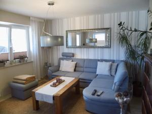 吕贝克Ferienhaus Kunas的客厅配有蓝色的沙发和桌子