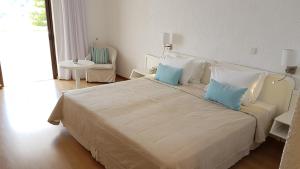 伊斯特隆伊斯佐恩海湾酒店的一间卧室配有一张大床和两个蓝色枕头